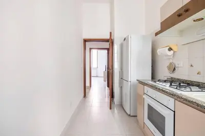 a white bedroom with a large bed with white sheets at Casa amoR in Trastevere in Rome