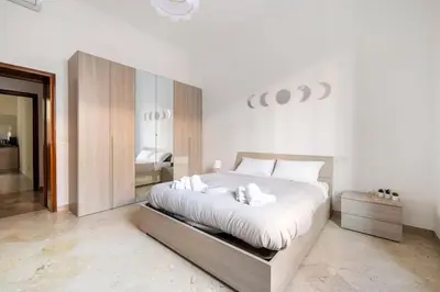 a white bedroom with a large bed with white pillows at Casa amoR in Trastevere in Rome