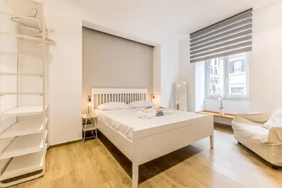 a white bedroom with a bed and a couch at Principe Umberto Suite - Stazione Termini in Rome
