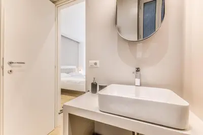 a white bathroom with a sink and a mirror at Principe Umberto Suite - Stazione Termini in Rome