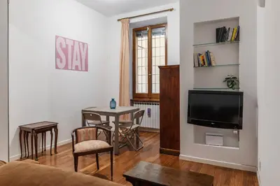 a living room with a tv and a table with chairs at A stone’s throw from the Colosseum! in Rome