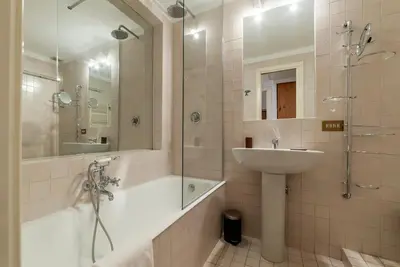 a bathroom with a tub and a sink and a shower at A stone’s throw from the Colosseum! in Rome