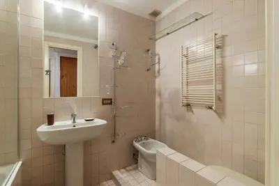 a bathroom with a sink and a toilet and a mirror at A stone’s throw from the Colosseum! in Rome