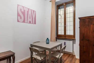 a table and chairs in a room with a sign on the wall at A stone’s throw from the Colosseum! in Rome