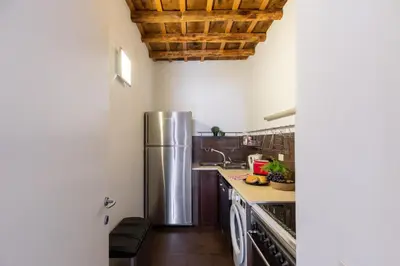 a kitchen with a stainless steel refrigerator and wooden ceilings at iFlat Homey in Campo de'Fiori in Rome