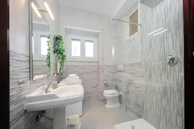a white bathroom with a sink and a toilet at Comfy apartment next to Vatican City in Rome