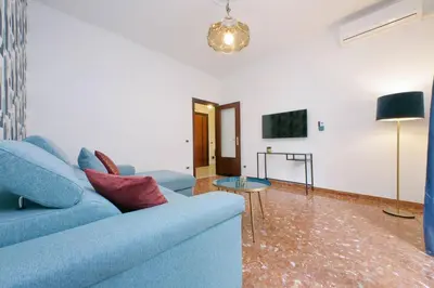a living room with a blue couch and a table at Comfy apartment next to Vatican City in Rome