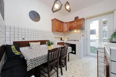 a kitchen with a table with chairs and a clock on the wall at Comfy apartment next to Vatican City in Rome