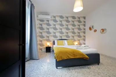 a bedroom with a bed with a yellow blanket at Comfy apartment next to Vatican City in Rome
