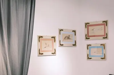 a group of four framed pictures on a wall at Termini Rita House in Rome