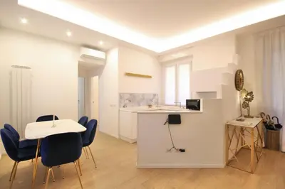 a living room with a table and chairs and a kitchen at HC - Live Doria Luxury Apt by the Vatican in Rome