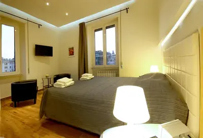 a bedroom with a large bed and two windows at Passenger Vatican Relais in Rome