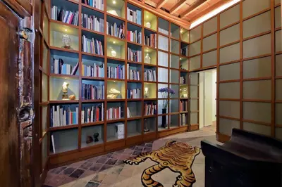 a library with a tiger statue in the middle of the room at The Eclectic Home of Collector - Navona Square in Rome