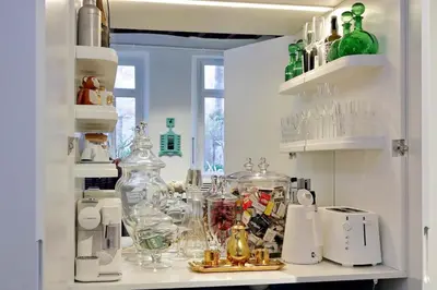 a kitchen filled with lots of glass items on a shelf at The Eclectic Home of Collector - Navona Square in Rome
