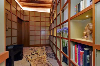 a hallway with bookshelves with tigers painted on the floor at The Eclectic Home of Collector - Navona Square in Rome
