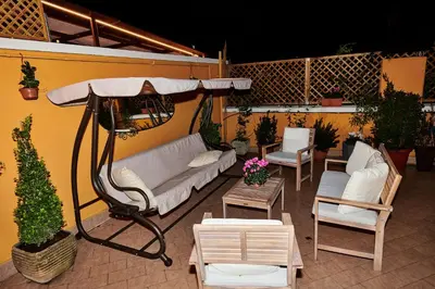 a patio with a white couch and a table and chairs at Terrace Penthouse - meospiti Penthouse in Rome