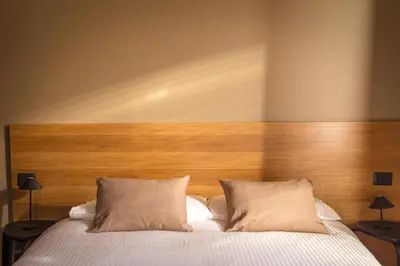a bed with a wooden headboard and two pillows at Testaccio Boutique Apartment in Rome in Rome
