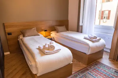 two beds in a room with towels on them at Testaccio Boutique Apartment in Rome in Rome