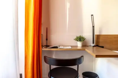 an orange curtain next to a desk with a chair at Testaccio Boutique Apartment in Rome in Rome