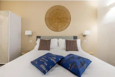 a bedroom with a white bed with blue pillows at Vatican 2BR apartment in Roma in Rome