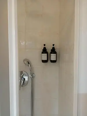 two bottles of soap are sitting in a shower at Rome - Termini House in Rome