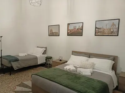 a bedroom with two beds and pictures on the wall at Rome - Termini House in Rome