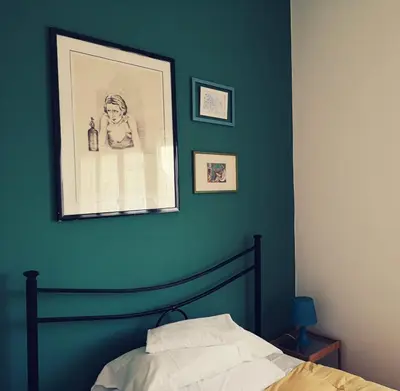 a bedroom with a blue wall with a bed at Porta Maggiore GH Locazione Turistica in Rome