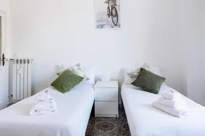 a pair of white beds in a room at Casa di Marianna e Vittorio al Gemelli in Rome