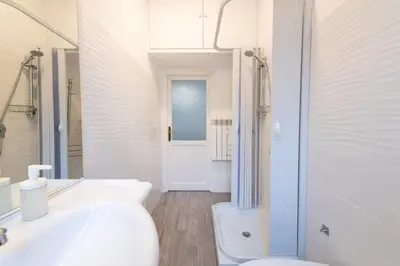 a white bathroom with a toilet and a sink at Casa di Marianna e Vittorio al Gemelli in Rome