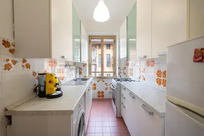 a kitchen with white cabinets and a yellow appliance on a counter at Casa di Marianna e Vittorio al Gemelli in Rome