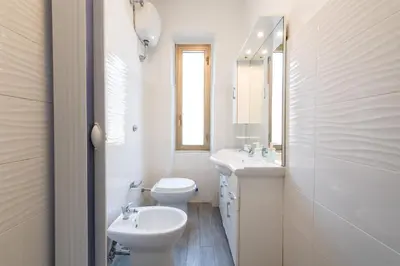a white bathroom with two toilets and a sink at Casa di Marianna e Vittorio al Gemelli in Rome