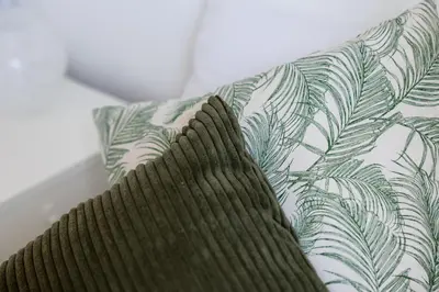 a green and white pillow with a leaf pattern on it at Casa di Marianna e Vittorio al Gemelli in Rome