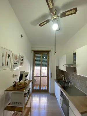 a kitchen with a ceiling fan and a kitchen counter at AURA APARTMENT in Rome