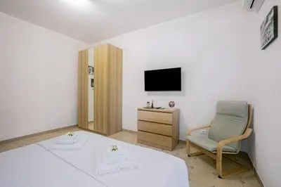 a bedroom with a bed and a chair and a television at Il rifugio dei nonni by Rentbeat in Rome