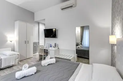 a hotel room with a large bed and a desk at Gardenia Suite in Rome