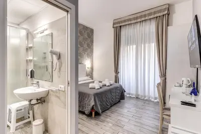a bathroom with a bed and a sink in a room at Gardenia Suite in Rome