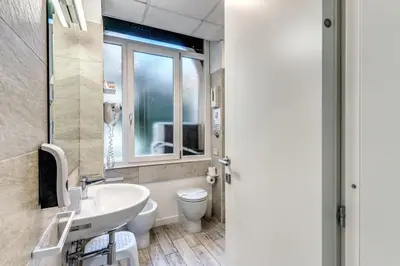 a bathroom with a sink and a toilet and a window at Gardenia Suite in Rome