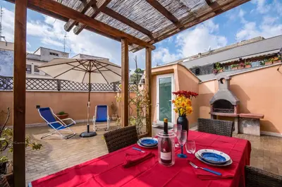 a patio with a table and an umbrella at Vatican Penthouse Near S.Peter's Square in Rome