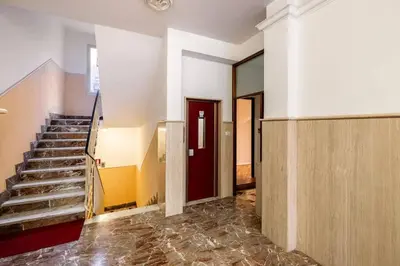 an empty room with stairs and a red door at alloggio la carica dei 101 in Rome