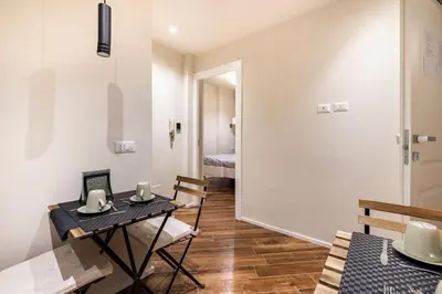 a room with a table and chairs and a bedroom at alloggio la carica dei 101 in Rome