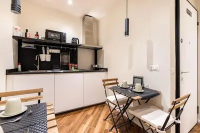 a kitchen with a table and chairs in a room at alloggio la carica dei 101 in Rome