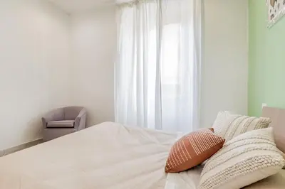 a bedroom with a bed with a chair and a window at La Rosa Dei Papi in Rome