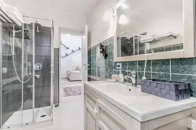 a white bathroom with a sink and a shower at La Rosa Dei Papi in Rome