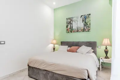 a bedroom with a large bed and a painting on the wall at La Rosa Dei Papi in Rome