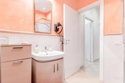 a bathroom with a sink and a mirror and a shower at La Rosa Dei Papi in Rome