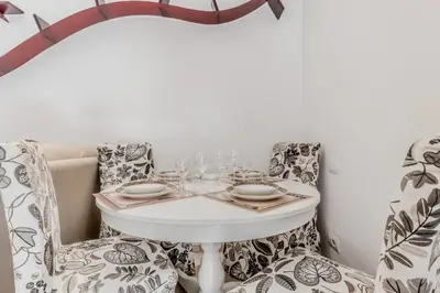 a table with two chairs and a white table with glasses at La Rosa Dei Papi in Rome