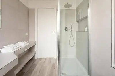 a white bathroom with a shower and a sink at Sweet Rhome to Colosseum in Rome