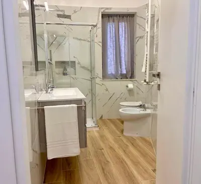a bathroom with a sink and a toilet and a mirror at PyramidHouse Rome - Apartment 100mq with View - 2km from the Colosseum in Rome