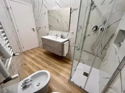 a white bathroom with a sink and a shower at PyramidHouse Rome - Apartment 100mq with View - 2km from the Colosseum in Rome