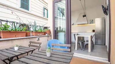 a patio with benches and a table and a kitchen at EasyTopStay - Trastevere Cozy Nest with Terrace in Rome